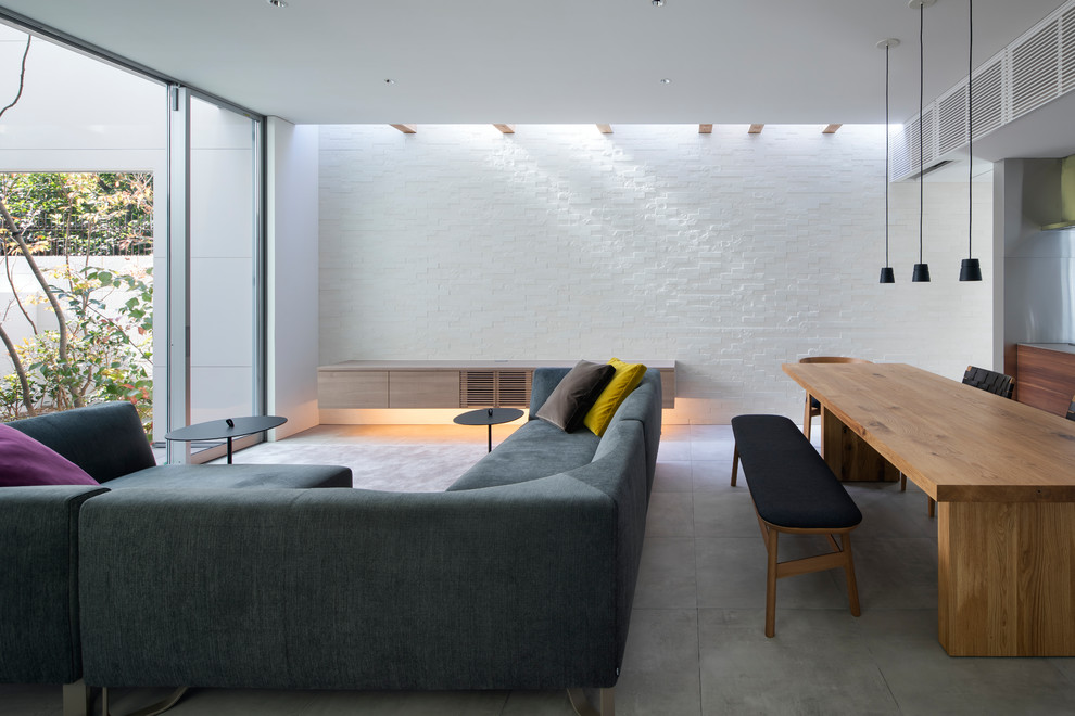 Photo of a medium sized contemporary open plan living room in Osaka with white walls, porcelain flooring, no fireplace, a freestanding tv and grey floors.