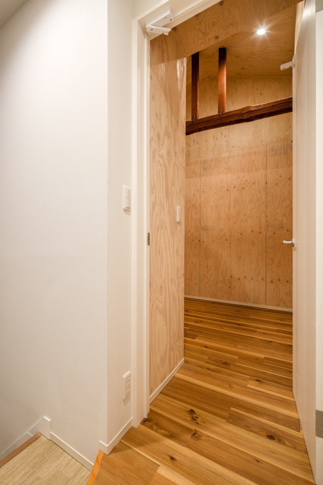 Foto de salón tipo loft escandinavo de tamaño medio sin chimenea con paredes beige, suelo de madera en tonos medios, suelo beige, madera y madera