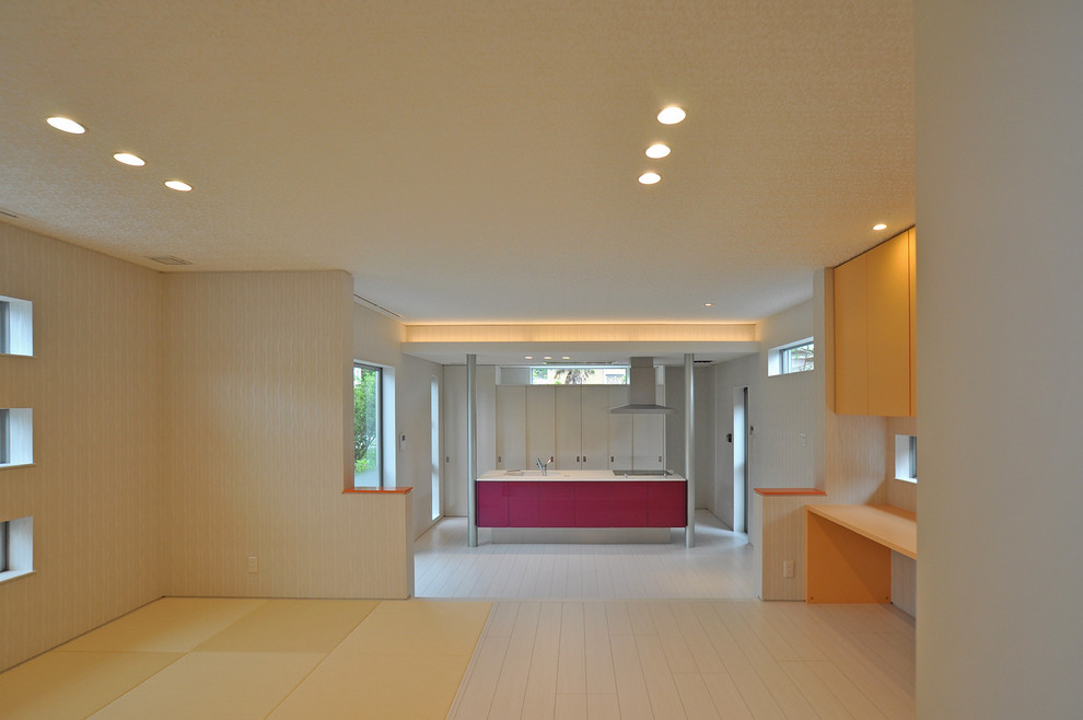 Modelo de salón abierto minimalista grande con paredes blancas, suelo de contrachapado, televisor colgado en la pared y suelo blanco