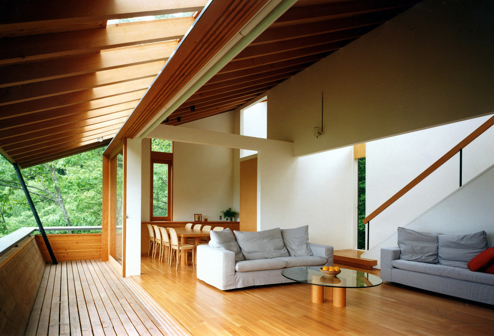 Imagen de salón escandinavo sin chimenea y televisor con paredes blancas y suelo de madera en tonos medios