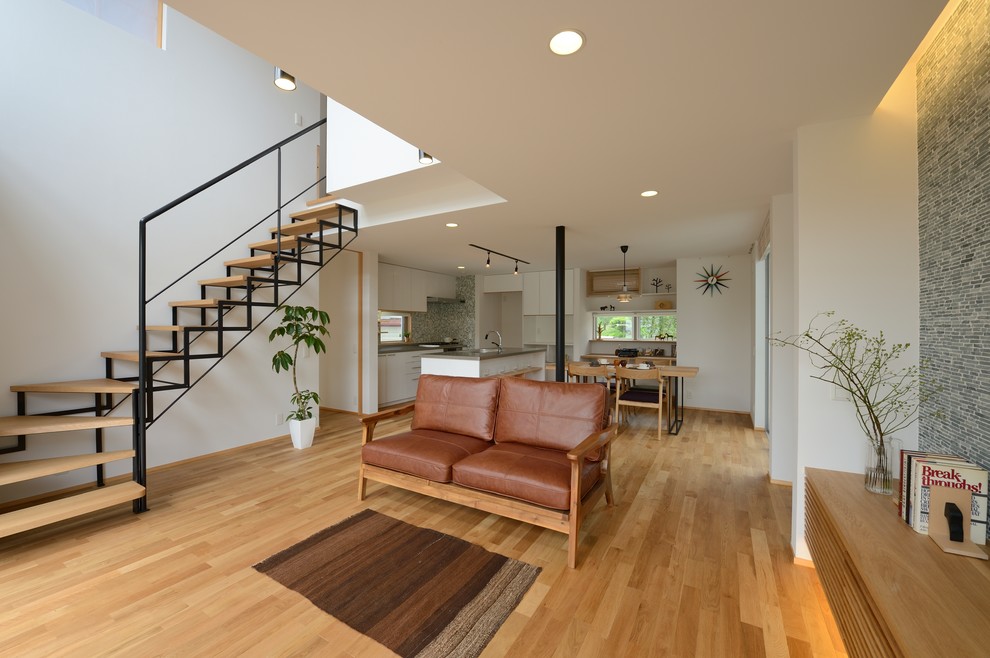 Idee per un soggiorno stile marino aperto con pareti bianche, pavimento in legno massello medio e pavimento marrone