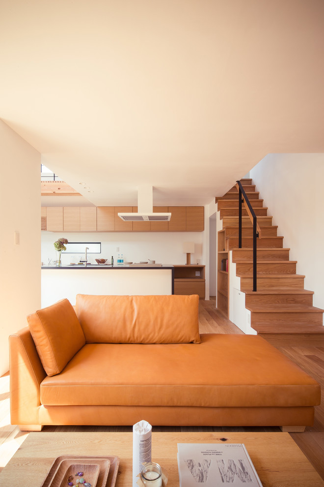 Inspiration för ett minimalistiskt allrum med öppen planlösning, med vita väggar, ljust trägolv och brunt golv