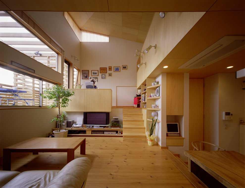 Danish medium tone wood floor and brown floor living room photo in Tokyo with white walls and a tv stand