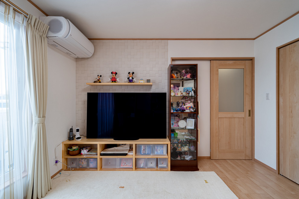 Offenes Wohnzimmer mit weißer Wandfarbe, Sperrholzboden, Tapetendecke und Tapetenwänden in Sonstige