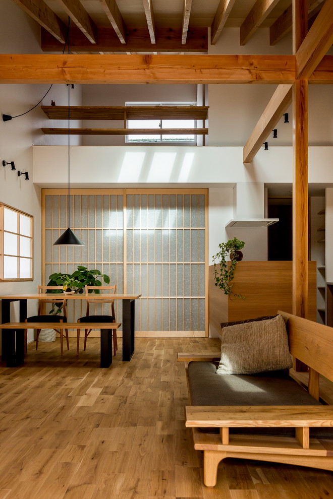 Offenes Asiatisches Wohnzimmer mit weißer Wandfarbe, braunem Holzboden und braunem Boden in Sonstige
