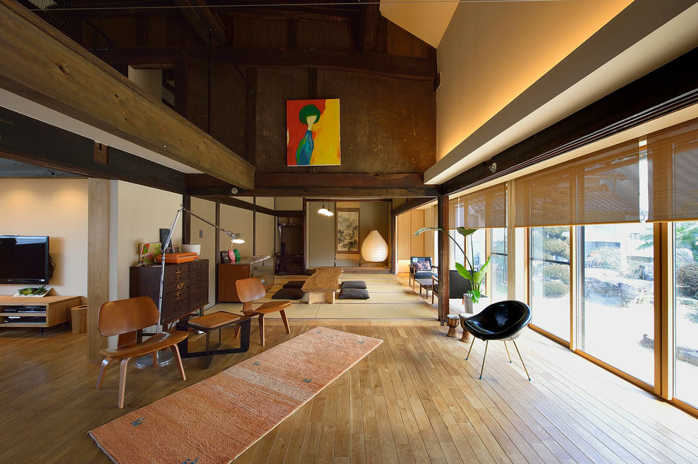 Foto di un ampio soggiorno etnico con pareti bianche, pavimento in legno massello medio e pavimento marrone