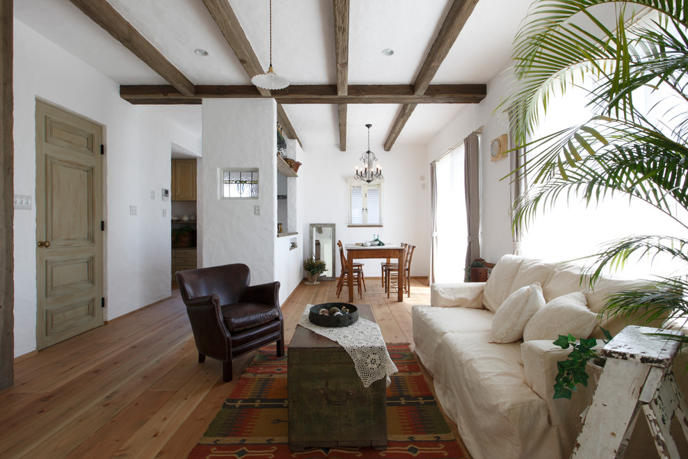 Idéer för lantliga vardagsrum, med vita väggar, mellanmörkt trägolv och brunt golv