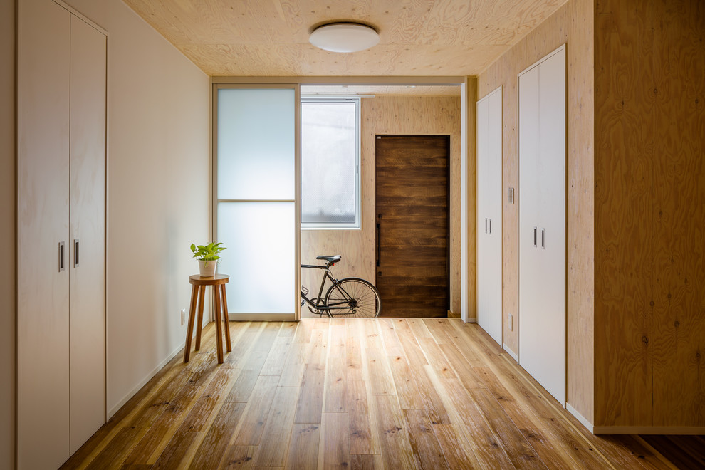 Idéer för en mellanstor minimalistisk entré, med bruna väggar, mellanmörkt trägolv, beiget golv och en skjutdörr