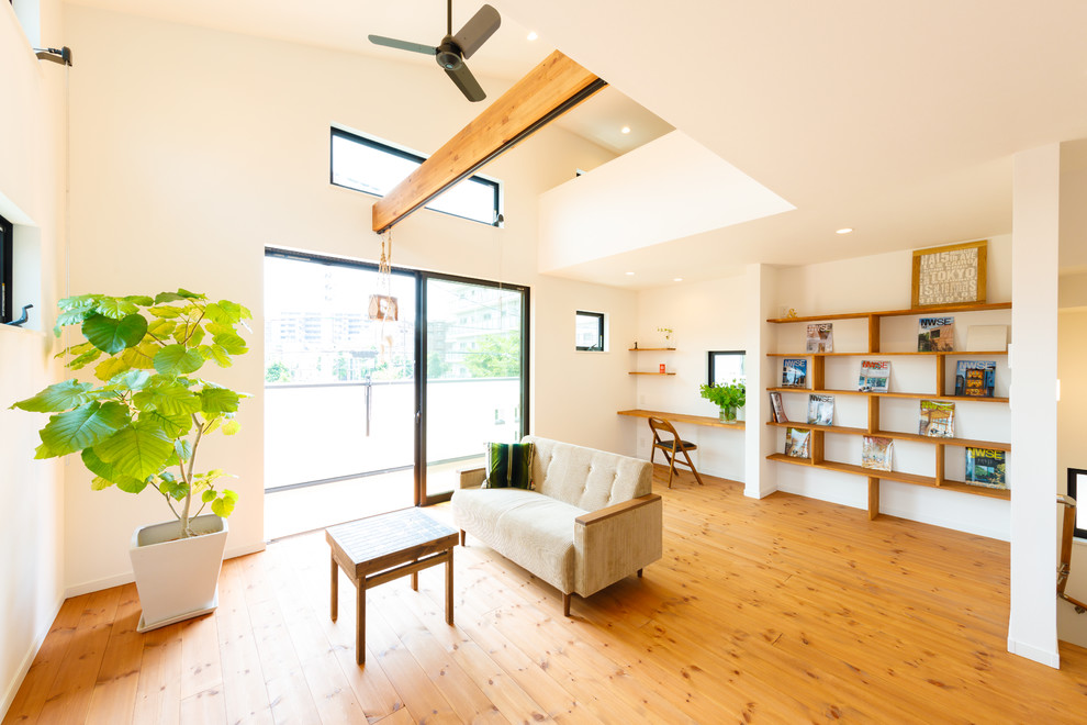 Modernes Wohnzimmer mit weißer Wandfarbe, braunem Holzboden und braunem Boden in Sonstige
