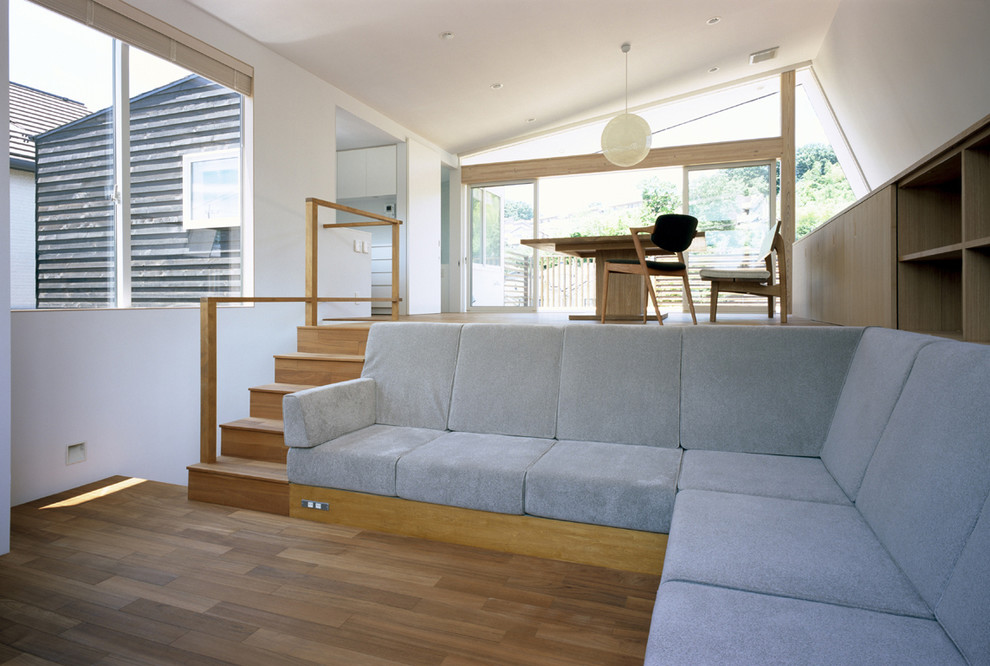Foto di un soggiorno design di medie dimensioni e aperto con pareti bianche, pavimento in legno massello medio, nessun camino e nessuna TV