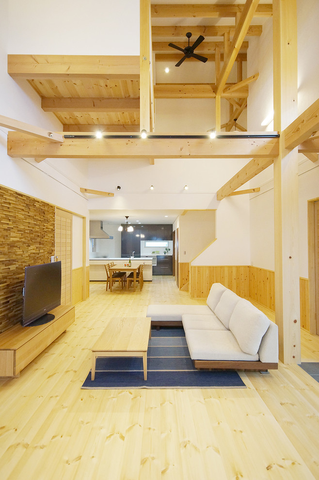 Imagen de salón abierto de estilo zen grande con paredes blancas, suelo de madera en tonos medios, televisor independiente y suelo beige