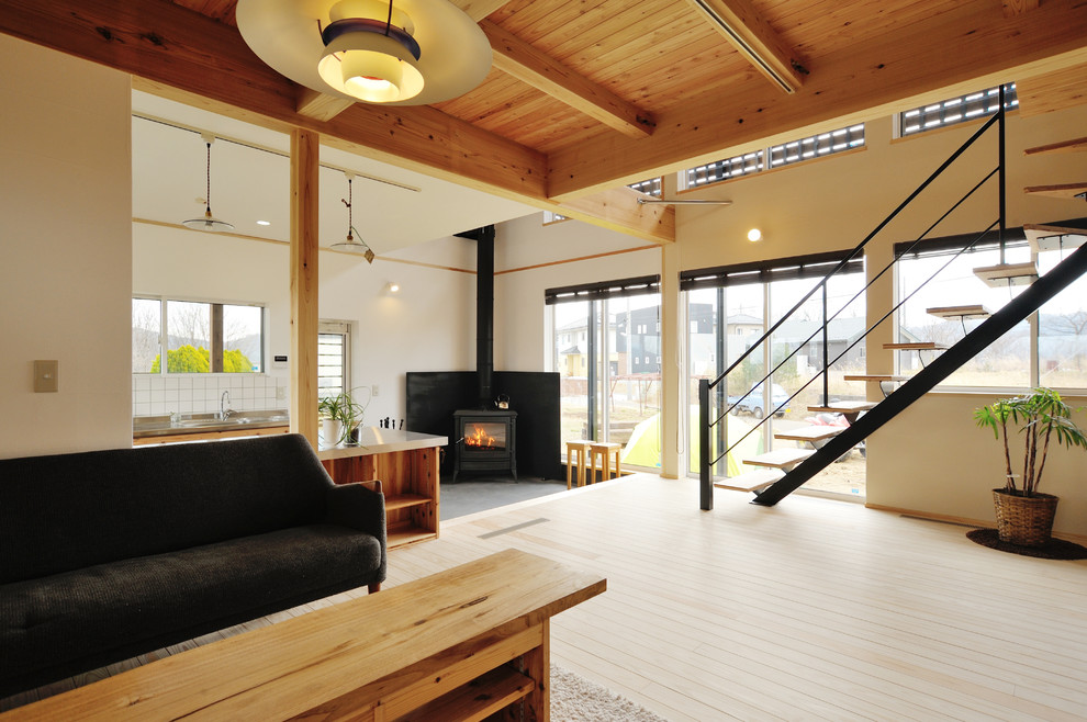 Idéer för ett asiatiskt vardagsrum, med en öppen vedspis, vita väggar, ljust trägolv och brunt golv