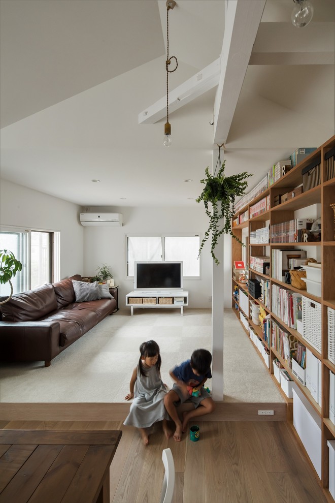 Kleines, Offenes Shabby-Look Wohnzimmer ohne Kamin mit weißer Wandfarbe, hellem Holzboden, freistehendem TV und weißem Boden in Sonstige