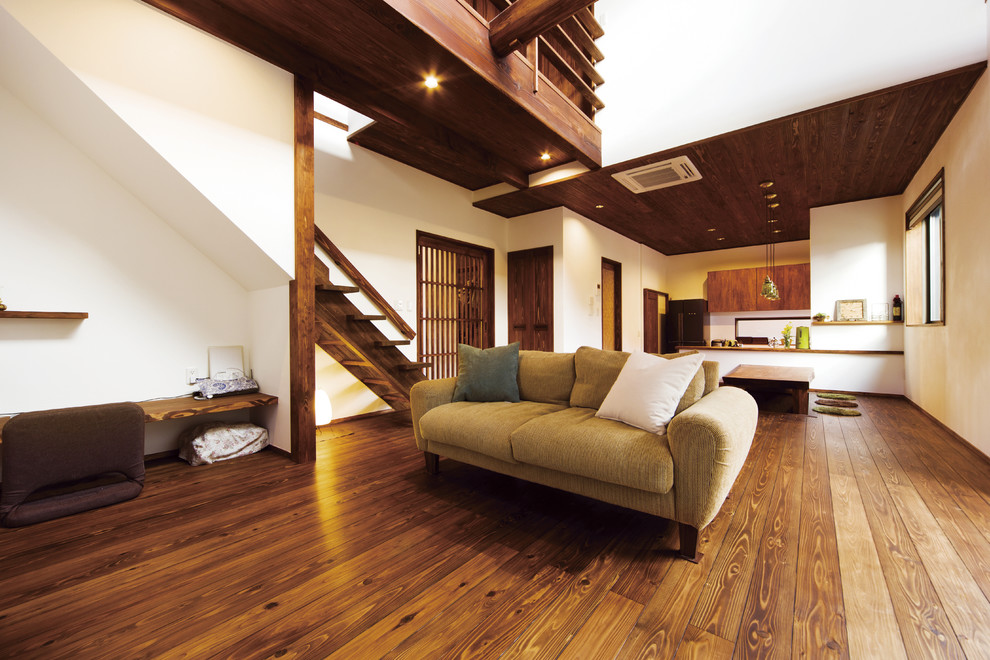 Diseño de salón abierto de estilo zen con paredes blancas, suelo de madera oscura y suelo marrón