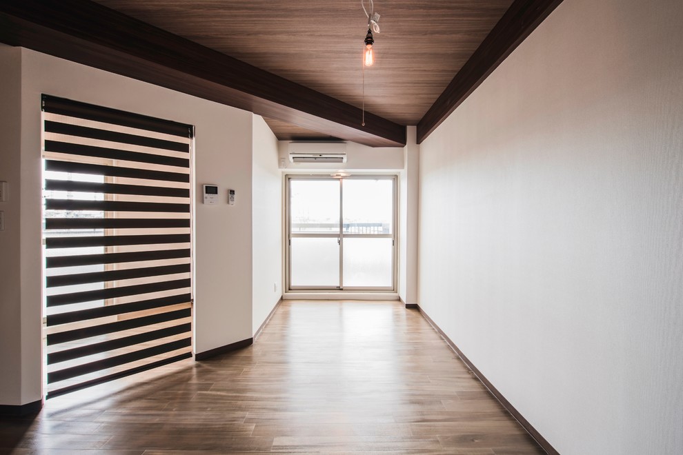 Cette image montre un salon minimaliste ouvert avec un mur blanc, un sol en contreplaqué, aucune cheminée, aucun téléviseur et un sol marron.