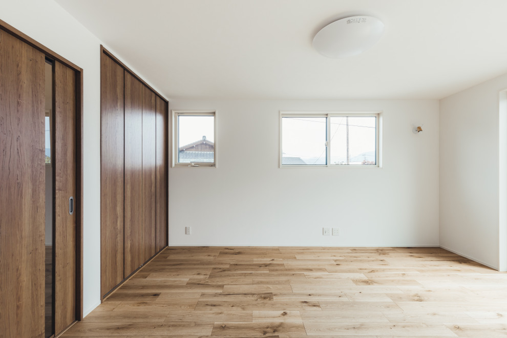 Abgetrenntes Asiatisches Wohnzimmer mit weißer Wandfarbe, Sperrholzboden, beigem Boden, Tapetendecke und Tapetenwänden in Sonstige