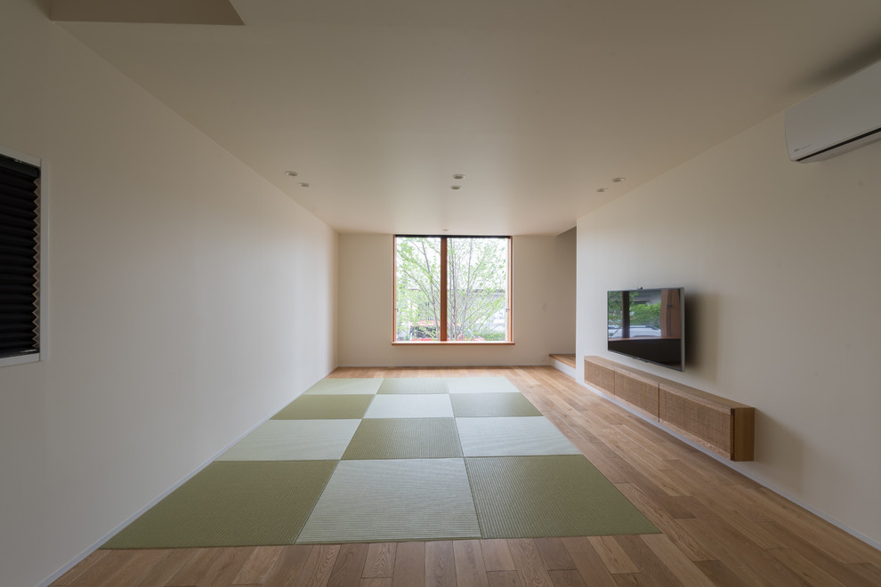 Asiatisches Wohnzimmer mit weißer Wandfarbe, Tatami-Boden und TV-Wand in Kyoto