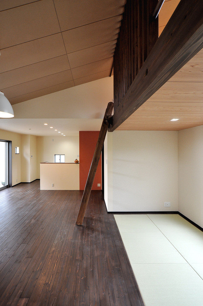 На фото: большая открытая гостиная комната в стиле модернизм с белыми стенами, темным паркетным полом, отдельно стоящим телевизором и коричневым полом