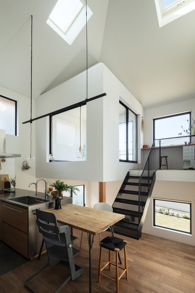 Aménagement d'un salon moderne de taille moyenne et ouvert avec un mur blanc, un sol en bois brun, aucune cheminée et un sol marron.