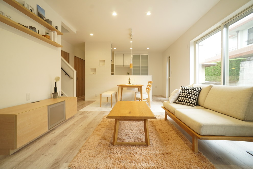 Offenes, Kleines Nordisches Wohnzimmer mit weißer Wandfarbe, Sperrholzboden und weißem Boden in Sonstige