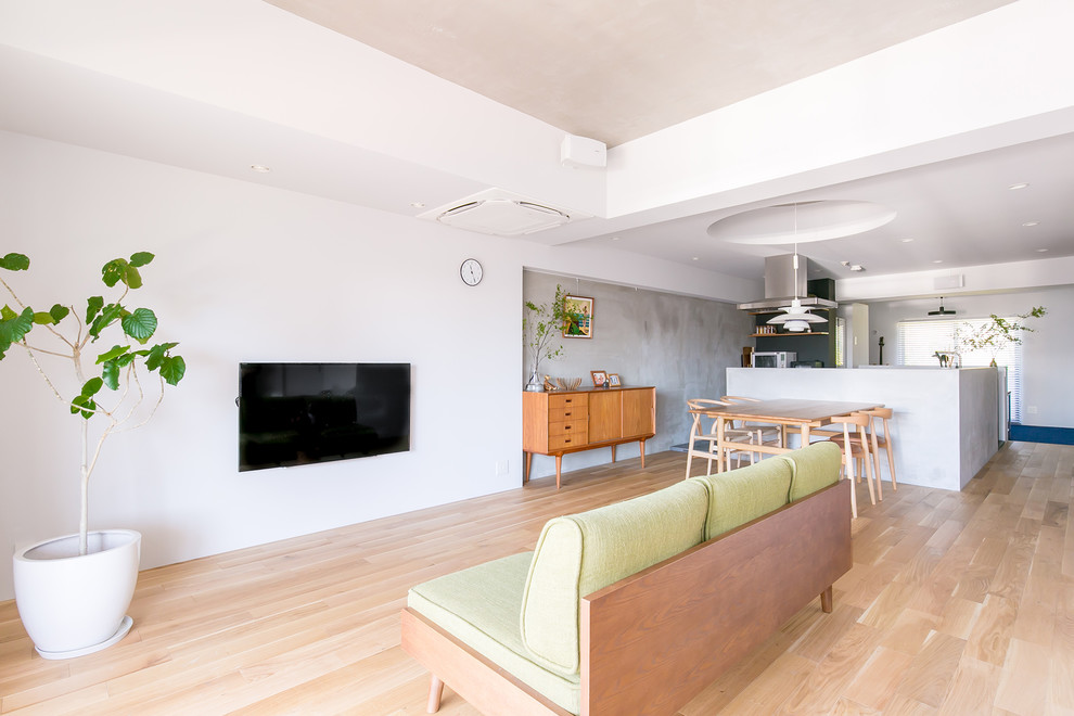 Modernes Wohnzimmer mit weißer Wandfarbe, hellem Holzboden, TV-Wand und braunem Boden in Nagoya