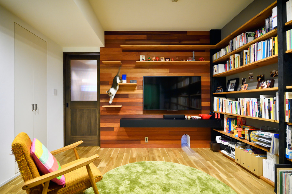 Idee per un soggiorno etnico chiuso con libreria, pareti beige, parquet chiaro, TV a parete e pavimento beige