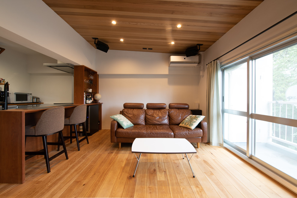Exemple d'un petit salon chic ouvert avec un mur blanc, un sol en bois brun et un sol marron.
