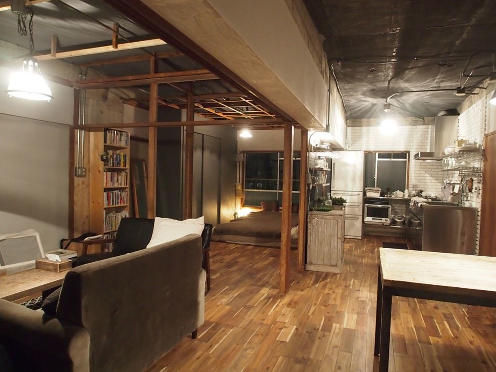 Imagen de salón abierto industrial pequeño con paredes multicolor, suelo de madera en tonos medios y suelo marrón