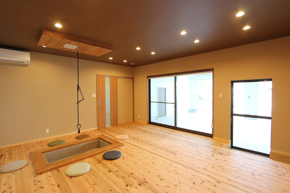 Idéer för orientaliska vardagsrum, med bruna väggar, mellanmörkt trägolv och brunt golv
