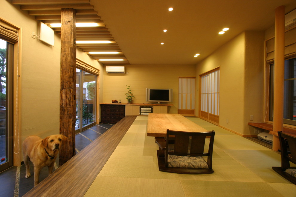 This is an example of a medium sized world-inspired living room in Osaka with beige walls, tatami flooring, a freestanding tv and beige floors.