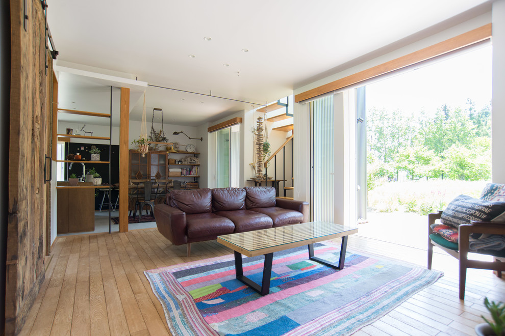 Immagine di un soggiorno stile americano di medie dimensioni e aperto con pareti bianche, pavimento in legno massello medio e nessun camino