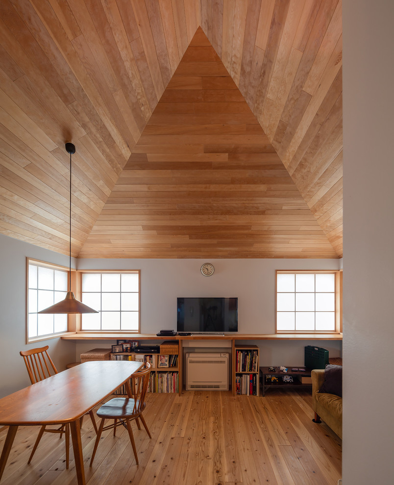 Imagen de salón actual con suelo de madera en tonos medios y televisor independiente
