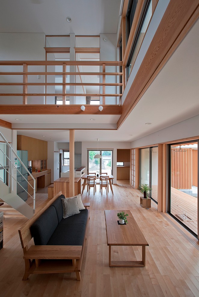 Ejemplo de salón abierto moderno sin chimenea con paredes blancas, suelo de madera clara, televisor independiente y suelo beige