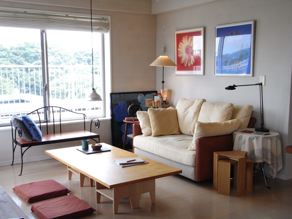 Asiatisches Wohnzimmer mit beiger Wandfarbe, gebeiztem Holzboden, freistehendem TV und beigem Boden in Tokio Peripherie