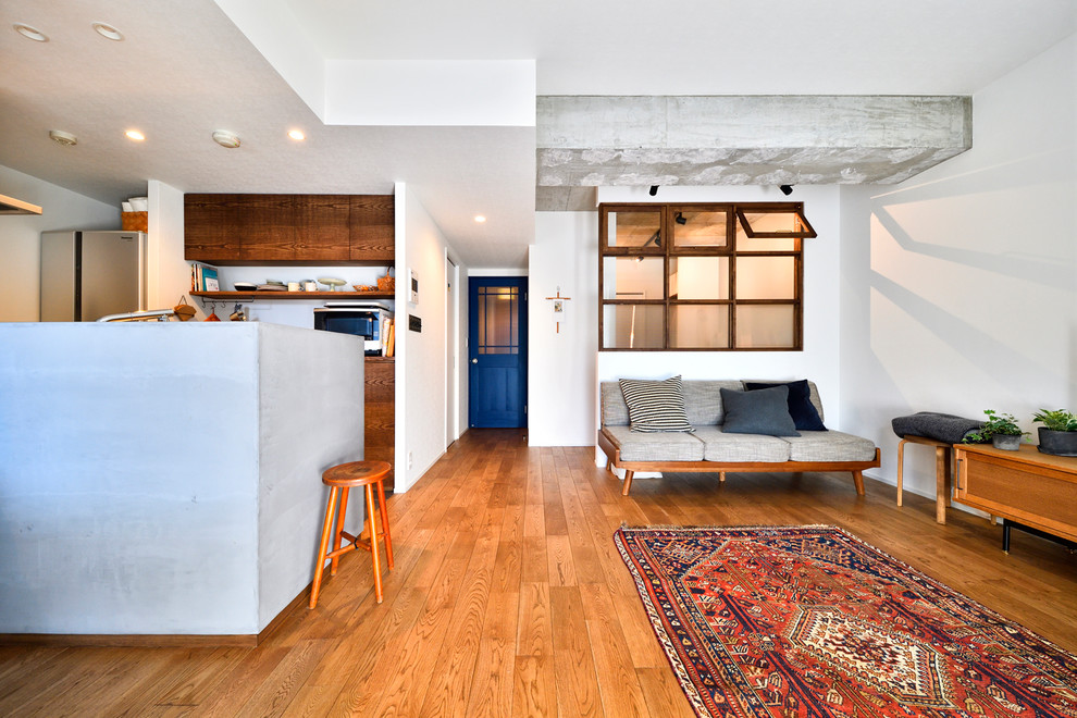 Immagine di un soggiorno design con pareti bianche, pavimento in legno massello medio e pavimento marrone
