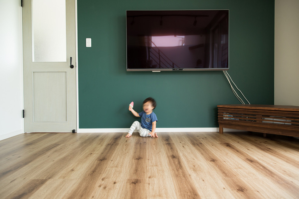 На фото: открытая гостиная комната в стиле модернизм с зелеными стенами, паркетным полом среднего тона, телевизором на стене, коричневым полом, потолком с обоями и стенами из вагонки без камина