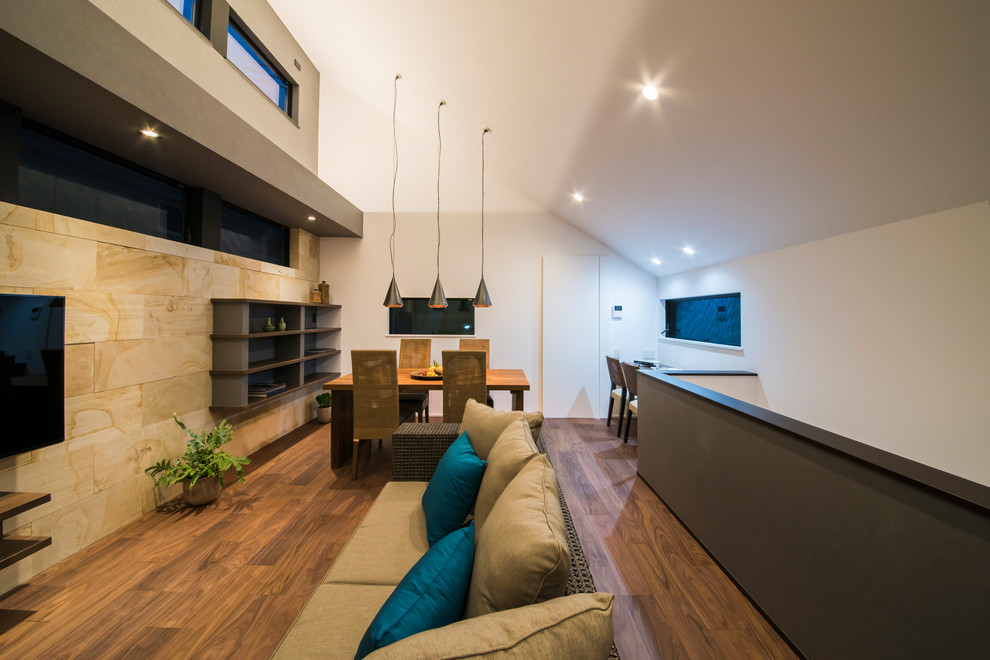 Design ideas for a large world-inspired open plan living room in Tokyo Suburbs with multi-coloured walls, medium hardwood flooring, a wall mounted tv and brown floors.
