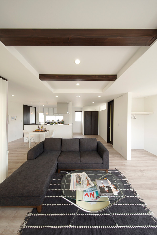 Example of a minimalist plywood floor and beige floor living room design in Other with white walls, no fireplace and a tv stand