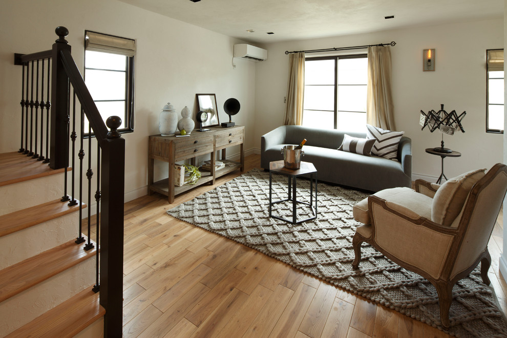 Пример оригинального дизайна: гостиная комната в стиле неоклассика (современная классика) с белыми стенами, паркетным полом среднего тона и коричневым полом