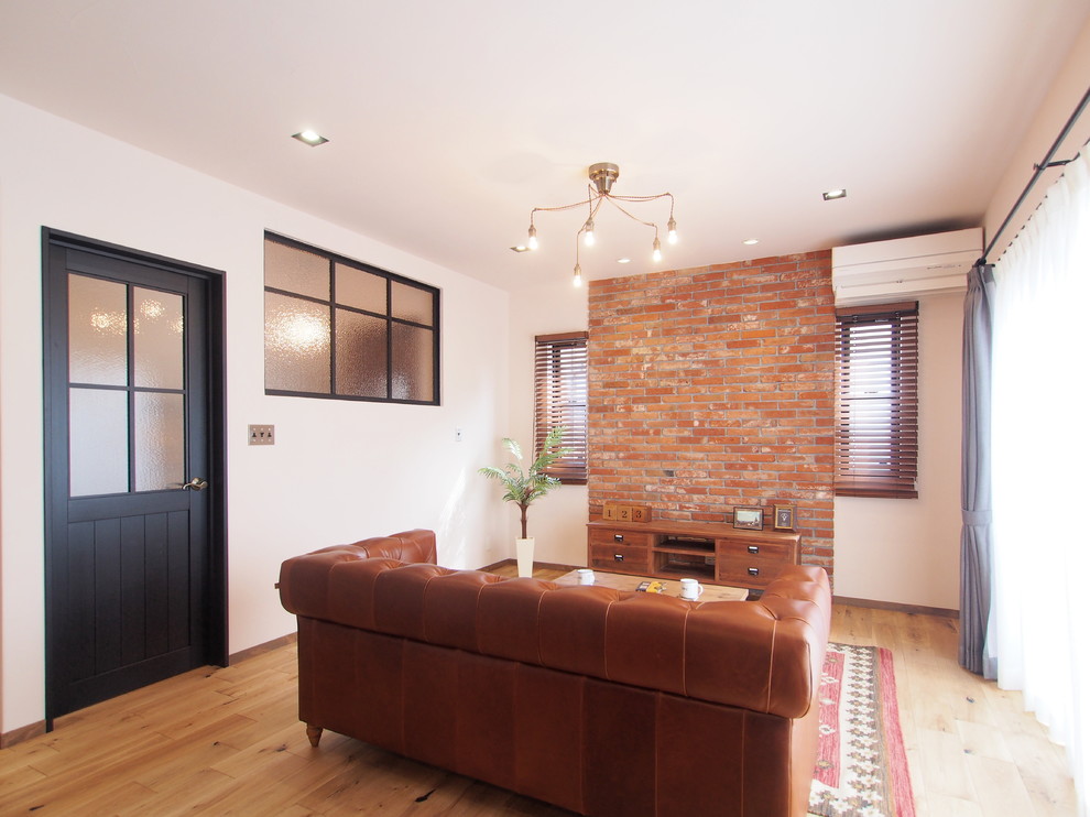 Aménagement d'un salon industriel avec un mur blanc, parquet clair et un sol marron.