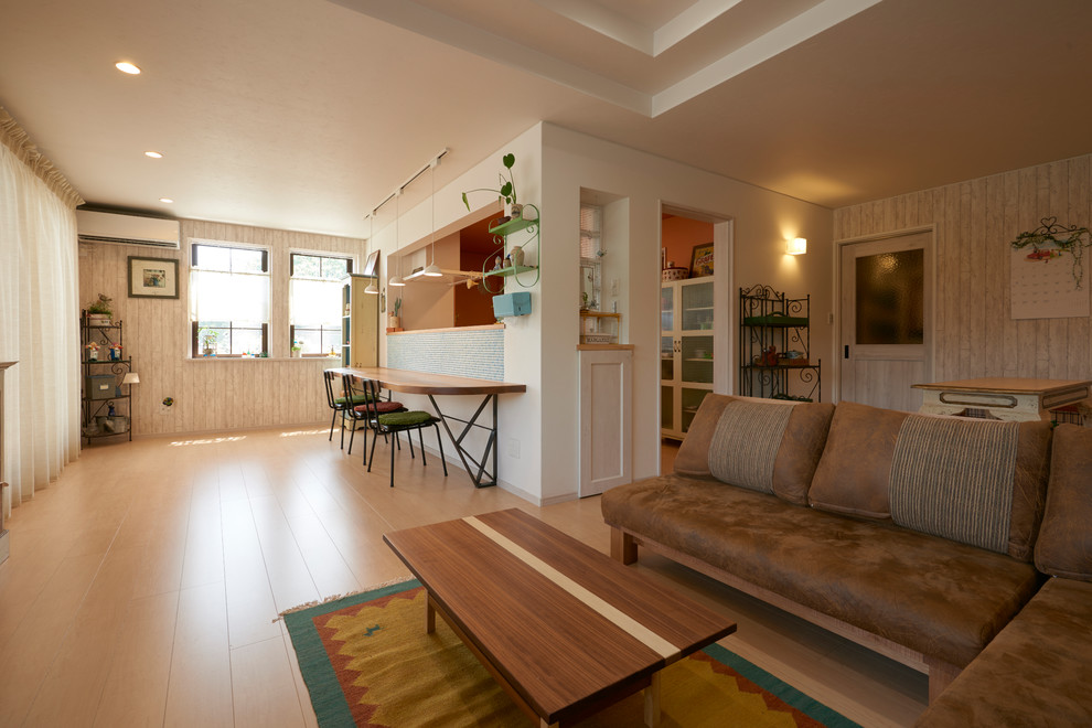 Источник вдохновения для домашнего уюта: открытая гостиная комната в стиле шебби-шик с белыми стенами, полом из фанеры, отдельно стоящим телевизором и бежевым полом без камина