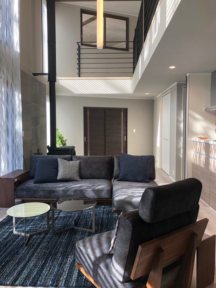 Großes, Repräsentatives Modernes Wohnzimmer mit grauer Wandfarbe, Sperrholzboden, grauem Boden und freistehendem TV in Sonstige