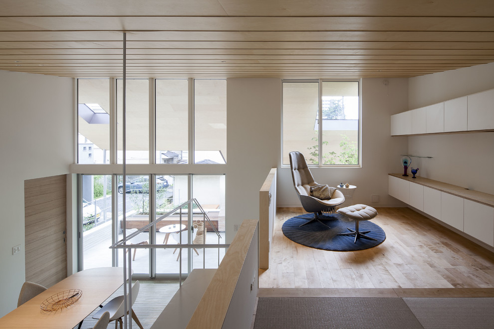 Idéer för ett asiatiskt loftrum, med vita väggar, ljust trägolv och beiget golv