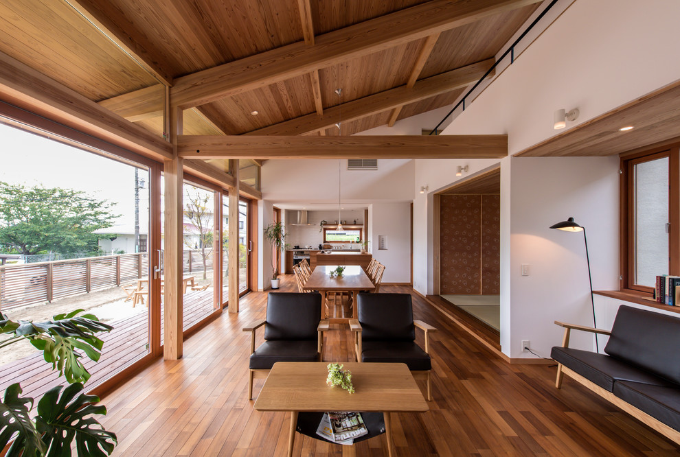 Living room - zen open concept medium tone wood floor and brown floor living room idea in Other with white walls