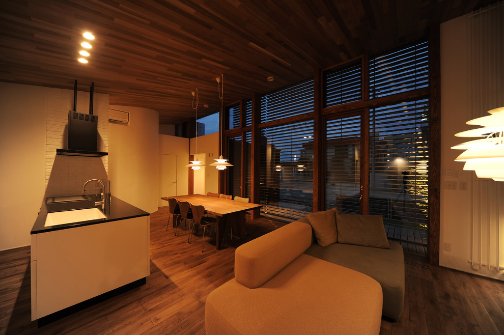 Idées déco pour un salon moderne ouvert avec un mur blanc et un sol en bois brun.