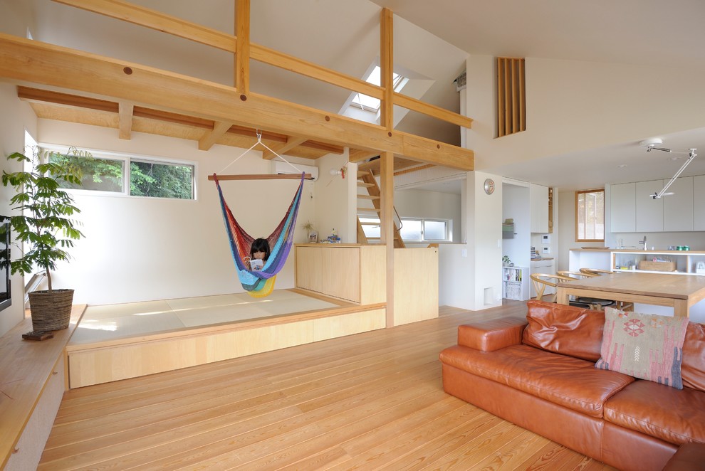 Offenes Skandinavisches Wohnzimmer mit weißer Wandfarbe, hellem Holzboden, TV-Wand und beigem Boden in Sonstige