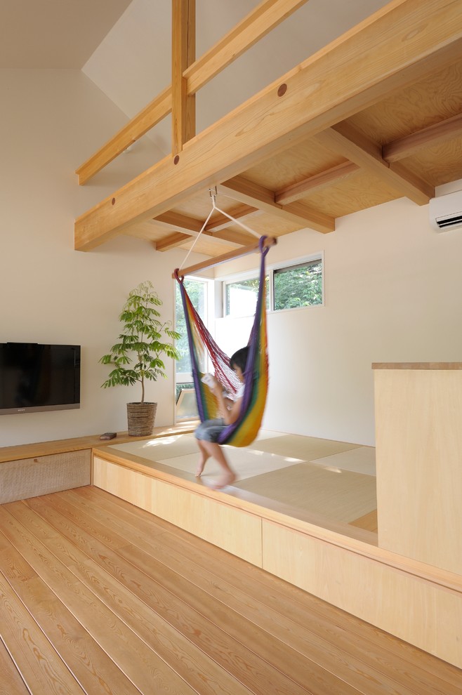 Bild på ett minimalistiskt allrum med öppen planlösning, med vita väggar, tatamigolv, en väggmonterad TV och grönt golv