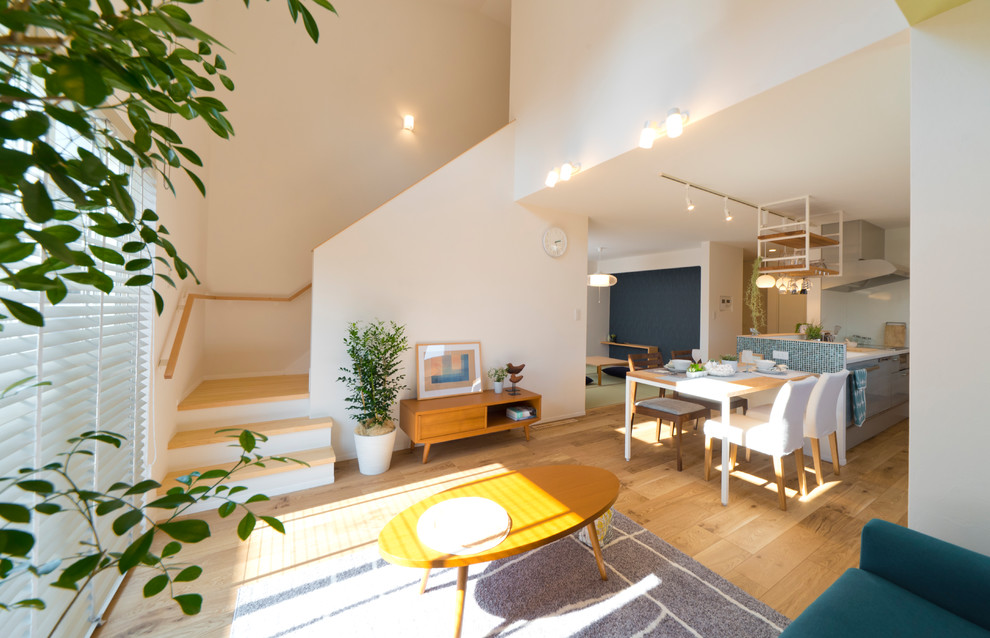 Idee per un soggiorno scandinavo con pareti bianche, pavimento in legno massello medio e pavimento marrone