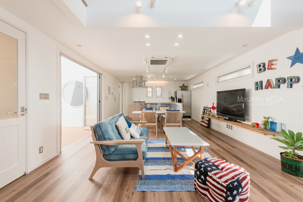 Maritimes Wohnzimmer mit weißer Wandfarbe, freistehendem TV und braunem Boden in Osaka