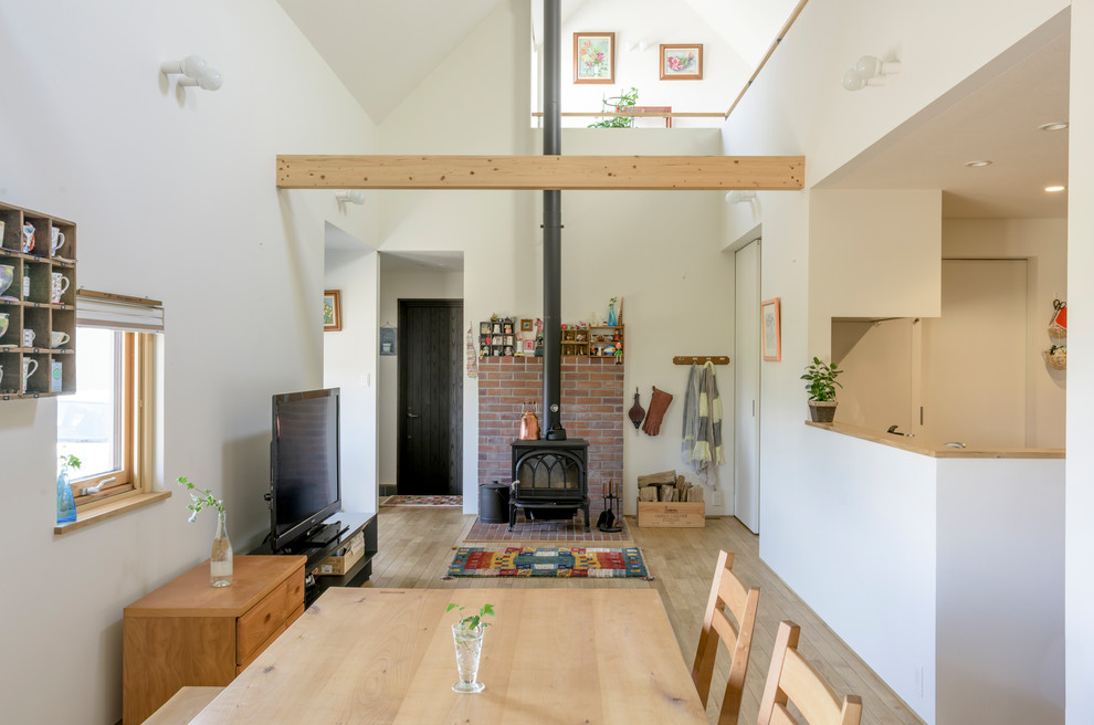Foto di un soggiorno nordico con pareti bianche, pavimento in legno massello medio, TV autoportante e pavimento marrone
